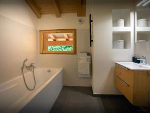 ein Badezimmer mit Badewanne und Waschbecken in der Unterkunft Chalet Morris - OVO Network in Sixt + 20 Fotos
