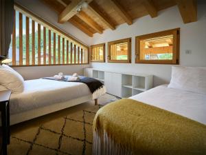 ein Schlafzimmer mit 2 Betten und einem Teddybär auf einer Decke in der Unterkunft Chalet Morris - OVO Network in Sixt