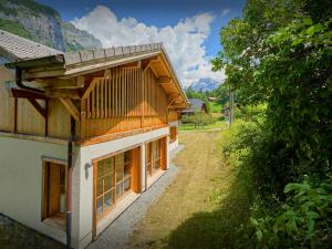 ein Haus mit Holzdach und Garten in der Unterkunft Chalet Morris - OVO Network in Sixt