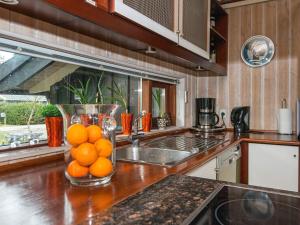 a kitchen with a vase filled with oranges on a counter at 8 person holiday home in Glesborg in Glesborg +13 photos