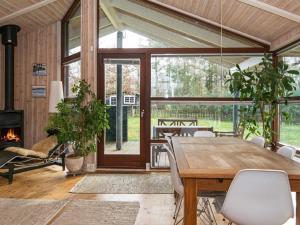 a dining room with a table and a fireplace at 8 person holiday home in Glesborg in Glesborg