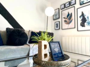 a living room with a coffee table with a book and a plant at Blueberry View - Wyndale Living - Central Worcester in Worcester