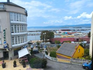 a view of a city with a building and a harbor at Hotel O Noso Portosin in Portosin