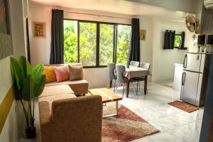 a living room with a couch and a table and a refrigerator at Gensan Apartment Rental in General Santos