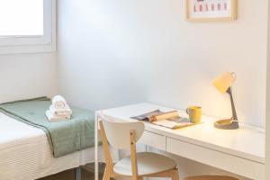 a bedroom with a desk and a bed with a chair at Acogedor Loft a 15 minutos del centro de Pamplona in Pamplona