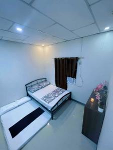 a room with two beds and a table in it at Gensan Staycation by Queen in Lagao III
