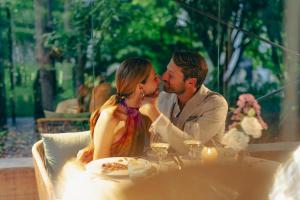 加尔达湖滨TreeLodgy, The Tree House的一男一女坐在桌边接吻