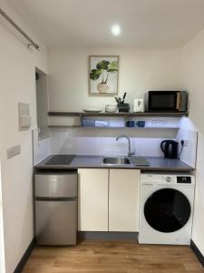 a small kitchen with a sink and a microwave at Modern Spacious Crawley Studio in Crawley