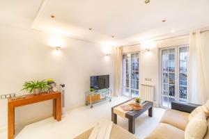 Una sala de estar con un sofá y un televisor. en Acogedor apartamento en el corazón de Pamplona, en Pamplona