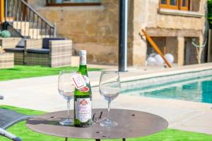 a bottle of champagne and two wine glasses on a table at Espectacular casa rural con piscina y barbacoa in Añorbe