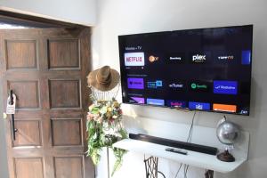 einen Flachbild-TV an einer Wand neben einer Tür in der Unterkunft Rose Cottage in Pretoria