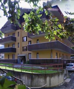 a yellow building with a fence in front of it at Residenza Giardino in Aprica