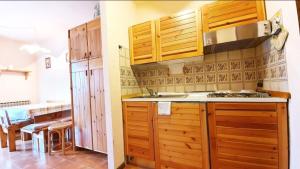 a kitchen with wooden cabinets and a counter top at Residenza Giardino in Aprica