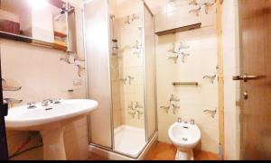 a bathroom with a sink and a shower and a toilet at Residenza Giardino in Aprica