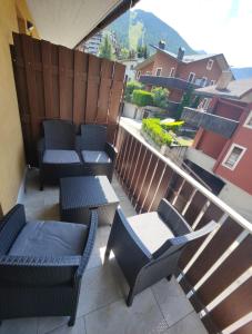 a patio with chairs and tables on a balcony at Residenza Giardino in Aprica