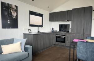 a living room with a couch and a kitchen at Vakantiepark de Zeeuwse Parel - Zeeparel in Sint Maartensdijk