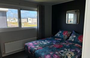 a bedroom with a bed and a window at Vakantiepark de Zeeuwse Parel - De Zeester in Sint Maartensdijk