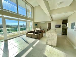 a large living room with a couch and a table at Atlântida Green Square - 607A in Xangri-lá