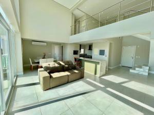 a large living room with a couch and a kitchen at Atlântida Green Square - 607A in Xangri-lá