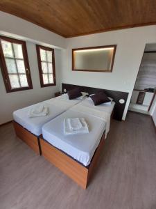 two large beds in a room with two windows at Sweetdreams Guest House in Gjirokastër