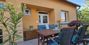 a patio with a wooden table and chairs at Szőlő Apartman in Villány