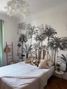 a bedroom with a bed with palm trees on the wall at Appartement niçois au coeur du triangle d'or in Nice +4 photos