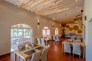 a dining room with tables and chairs and windows at Nawan Resort Serrano in Jesús María