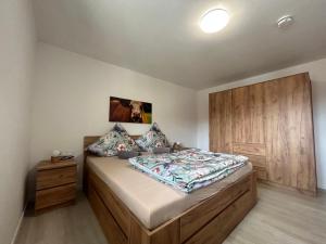 a bedroom with a bed and a wooden cabinet at Allgäu Moments Oberstaufen in Oberstaufen