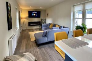 a living room with a blue couch and a tv at 1-Bed Apartment Near Nenagh & Lough Derg in Hackstown Bridge