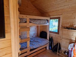 a bedroom with bunk beds in a log cabin at Magiczny domek in Drzewoszewo