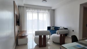 a living room with a couch and a table and chairs at City Charm in Nairobi