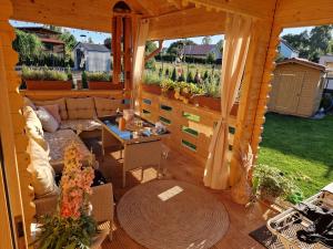 an outdoor living room with a couch and a table at Magiczny domek in Drzewoszewo