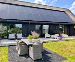 a table and chairs with solar panels on a house at Bed en breakfast Suite 8 in Langenboom