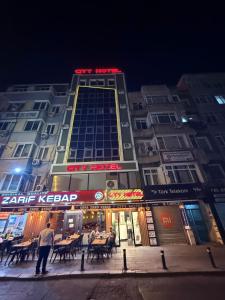 a building with people standing outside of it at night at City Hotel İstanbul in Istanbul