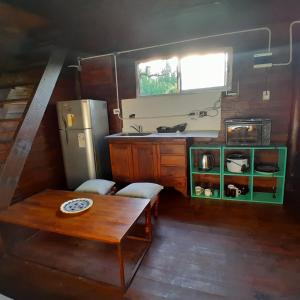 a small kitchen with a table and a refrigerator at Cabaña los sauces in Tigre +24 photos