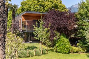 a house surrounded by trees and a fence at TreeLodgy, The Tree House in Riva del Garda