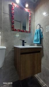 a bathroom with a sink and a mirror and a toilet at House Punto Patagonico Bariloche in San Carlos de Bariloche