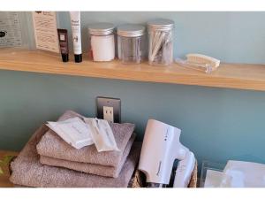 a shelf with a hair dryer on top of towels at Tomareru Relaxation salon Yukiki - Vacation STAY 29653v in Kawagoe +20 photos