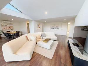 a living room with a white couch with a teddy bear on it at 6-Bed Lake Escape for Families & Friends in Patterson Lakes