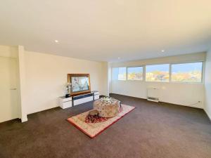 an empty living room with a couch and windows at 6-Bed Lake Escape for Families & Friends in Patterson Lakes +35 photos