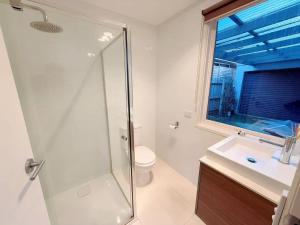 a bathroom with a shower and a toilet and a sink at 6-Bed Lake Escape for Families & Friends in Patterson Lakes