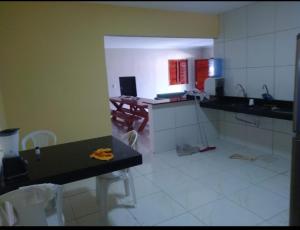 a kitchen with a counter and a table and chairs at André Safadão Turismo in Beberibe