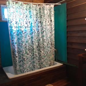 a shower curtain in a bath tub with a shower curtain at Cabaña los sauces in Tigre