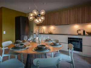 a kitchen with a dining room table with chairs and a chandelier at Lodge Sami - OVO Network in Samoëns