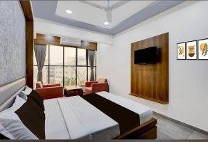 a hotel room with a bed and a tv and a room at Hotel Heritage Inn in Mahesāna