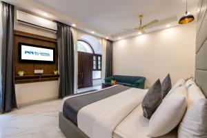 a bedroom with a large bed and a tv at Hotel PK Residency Sector 18 Noida in Noida