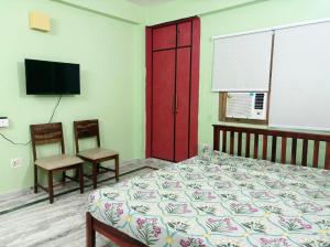a bedroom with a bed and a red door and a tv at Casa Pratap in Patna