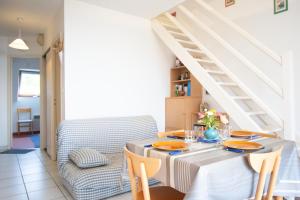 a dining room with a table and a staircase at Le Petit Bleu I Magnifique vue mer & Plage à 50m in Crozon +13 photos