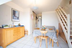 a kitchen and dining room with a table and chairs at Le Petit Bleu I Magnifique vue mer & Plage à 50m in Crozon
