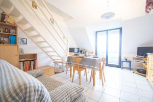a living room with a dining room table with chairs at Le Petit Bleu I Magnifique vue mer & Plage à 50m in Crozon